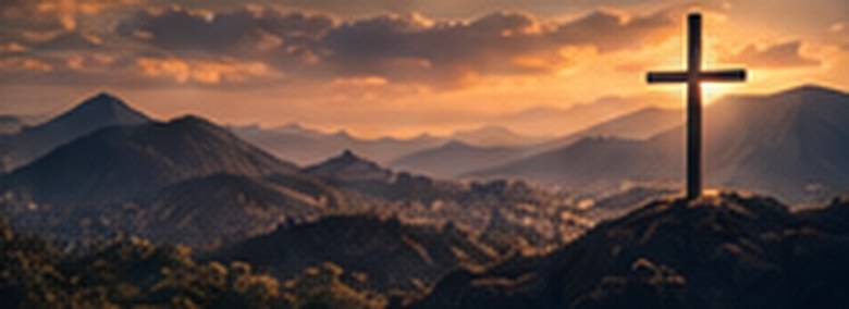 Montanhas ao pôr do sol com uma cruz no alto
